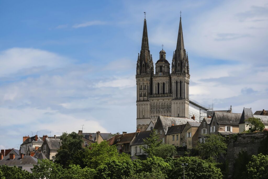 Angers Cathedral's towering spires under a vibrant sky in Pays de la Loire, France.
